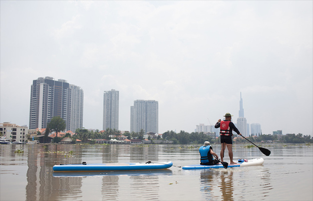 Two men Paddleboarding in the Saigon River | 4 Best Places to Exercise in Thao Dien for Free