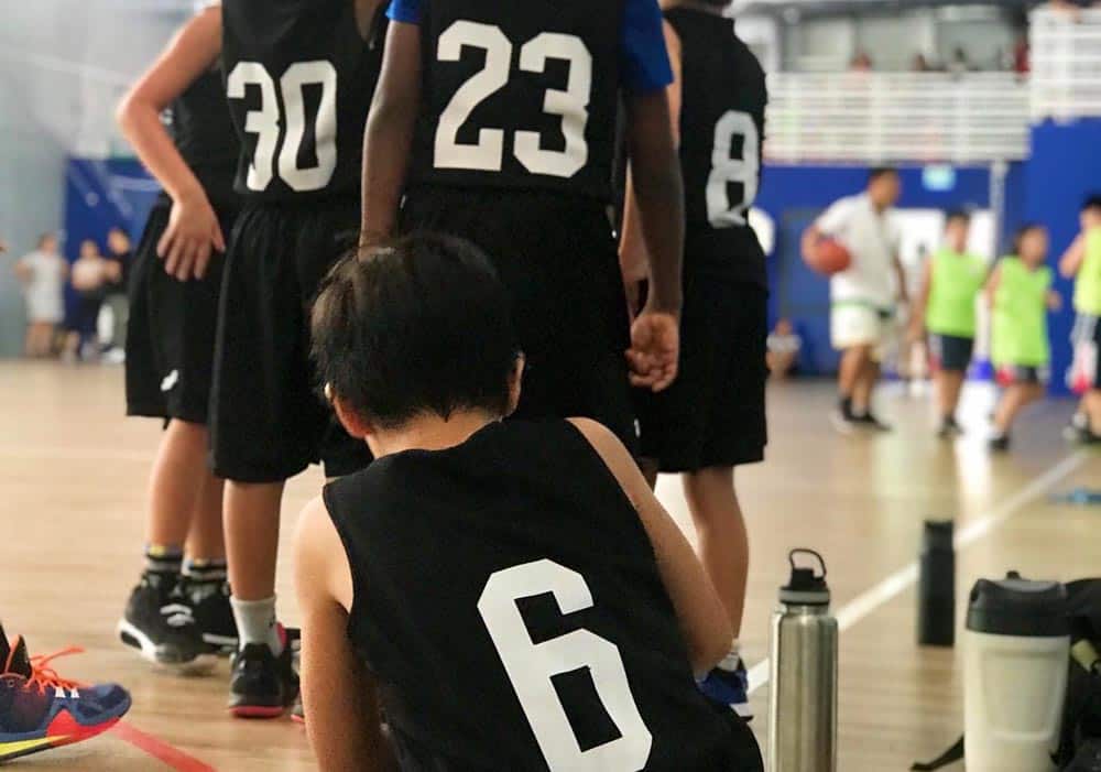 PSA-little-boy-tying-his-shoe-rear-view-behind-basketball-team-thaodienlife | BACK TO THE BASICS: Creating positive Youth Development structures for sport within a try hard culture in Ho Chi Minh City, Vietnam (2021) 